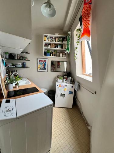 une petite cuisine avec un comptoir et un réfrigérateur dans l'établissement Charmant T2 parisien avec balcon, à Paris