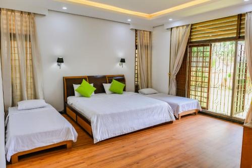 two beds in a room with two windows at Villa Bango in Cilember Udik 1