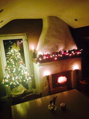 a christmas tree in a living room with a fireplace at Samona in Kilkeel