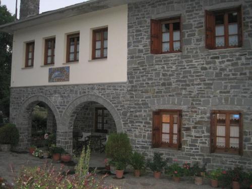 an external view of a stone house with windows at Hotel Tymfi in Tsepelovo