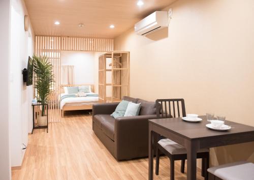 a living room with a couch and a table at Tycq Nagahashi TYレジデンス in Osaka
