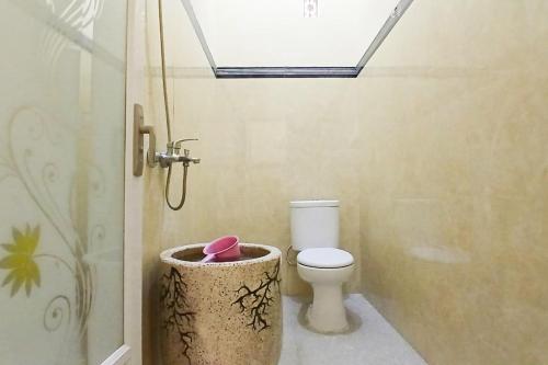 a bathroom with a toilet and a shower at RedDoorz at Dien Homestay Syariah Alun-alun Pasuruan in Krampijangan