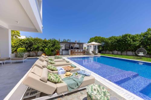 a backyard with a swimming pool and a villa at Villa Green Haven 2 Protaras Cyprus in Protaras