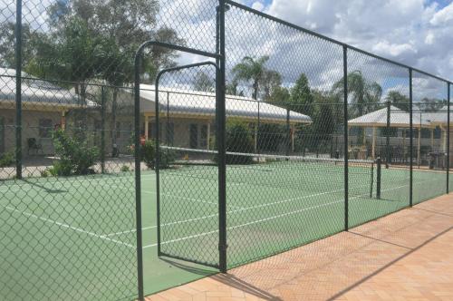 a tennis court with a net on a tennis court at Jolly Swagman Motor Inn in Goondiwindi