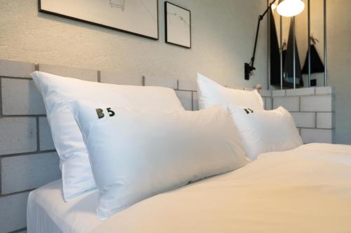 a white bed with white pillows on it at B5 Boutique & Design Hotel - Digital Check in - Adults Only in Lugano