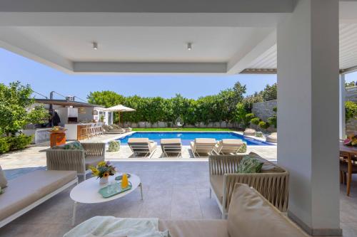 an outdoor living room with a pool and furniture at Villa Green Haven 2 Protaras Cyprus in Protaras