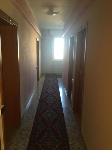 a hallway with a rug in the middle of a room at Hotel Vela Azzurra in Malcesine