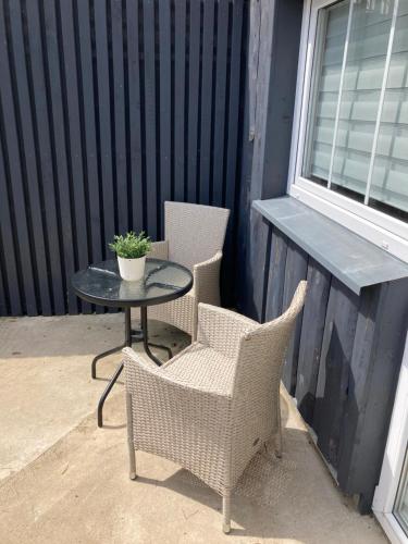 two wicker chairs and a table on a patio at Atostogu namelis in Anykščiai