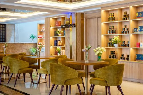 a restaurant with tables and chairs in a room at Sandals Lily Hotel in Da Lat