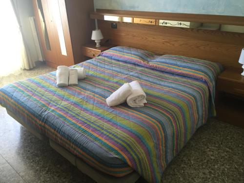 a bed with two rolled towels on it at Hotel Vela Azzurra in Malcesine