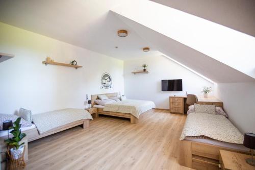 a attic room with two beds and a tv at Statek Hostačov 