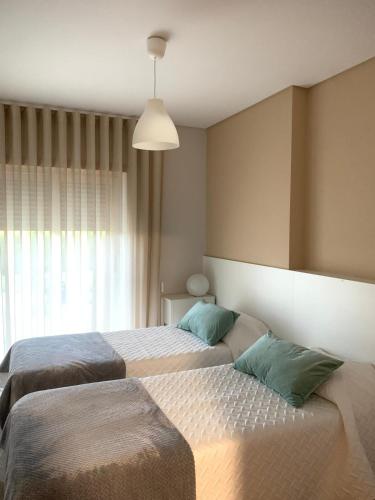 a bedroom with two beds and a large window at Casa Vilarelho in Caminha