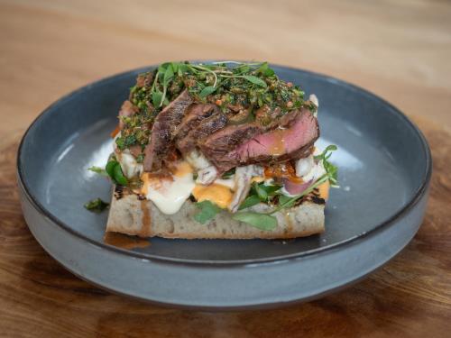 a sandwich with meat and vegetables on a blue plate at AtholPlace Hotel & Villa in Johannesburg