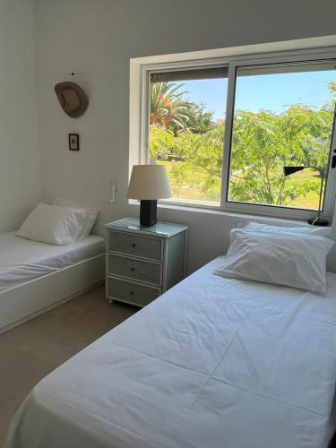 a bedroom with two beds and a large window at Andromeda Shell House in Pefkochori