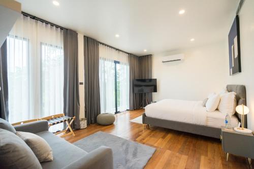 a large bedroom with a bed and a couch at Te Mata Glamping in Nong Nam Daeng