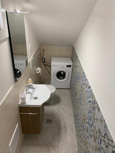 Un baño con lavabo y lavadora. en Casa vacanze Li Marini, en Lido Marini