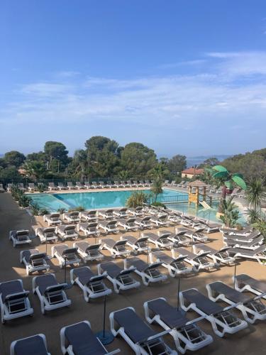 une rangée de chaises longues et une piscine dans l'établissement Mobile Evasion okpl SEGUR, à Saint-Raphaël