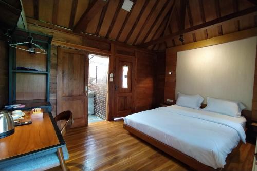 ein Schlafzimmer mit einem weißen Bett und einem Schreibtisch und einem Schreibtisch in der Unterkunft Argo limo Cottage Syariah Magelang in Tanayung