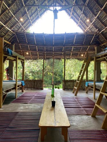 a wooden table in the middle of a room with a roof at Art Forest in Puducherry
