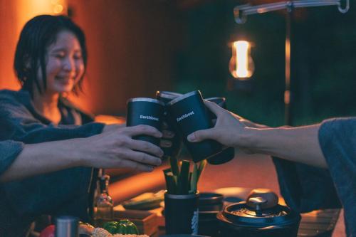 a woman is holding a book while another woman holds a cup at Earthboat Hakuba in Hakuba