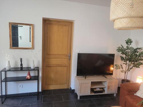 - un salon avec une télévision à écran plat à côté d'une porte dans l'établissement Appartement cosy avec exterieur au coeur de la Provence, à Monteux