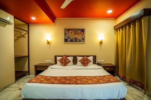 a bedroom with a large bed with two night stands at The Marwar Hotel & Gardens in Jodhpur