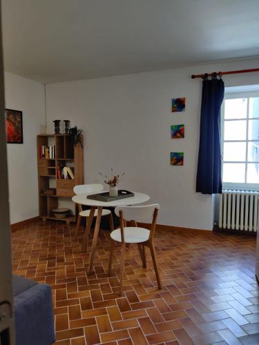 un salon avec une table et des chaises dans l'établissement maison sans soucis, à Villedieu