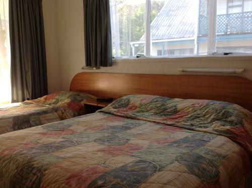 a hotel room with two beds and a window at Breeze Motels in Greymouth