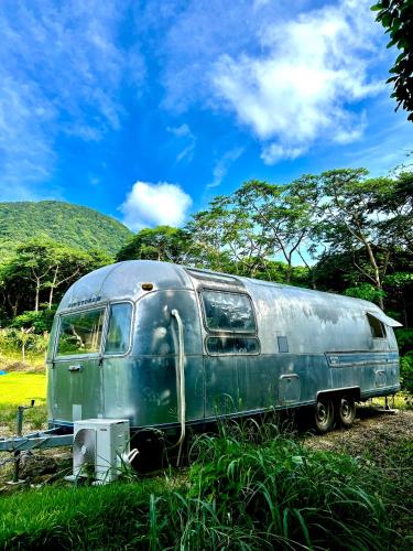 an old green van parked in a field at HoshinoHana ~ Beach house~ in Ishigaki Island