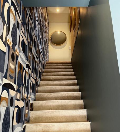 un escalier avec un mur en carreaux dans l'établissement Maison de bord de mer, à Lion-sur-Mer