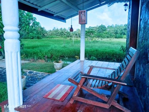 a wooden deck with a bench on a porch at ARA Place - Boossa - Private Villa in Boossa