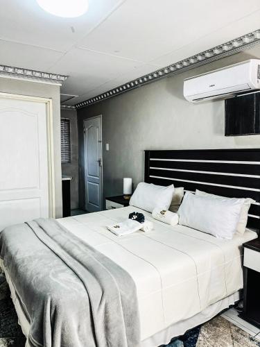 a bedroom with a large white bed in a room at Siyaya Sbosh BnB in Reitz