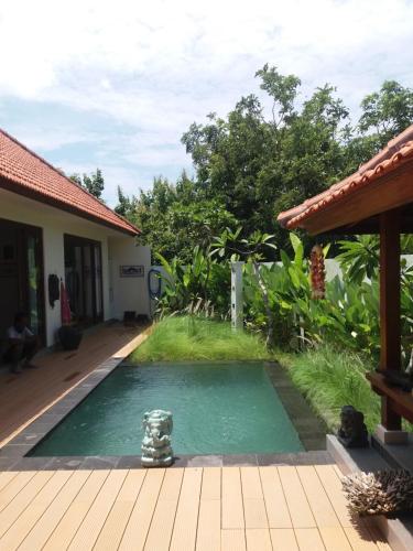 a swimming pool in the yard of a house at The Seaglass Villas Bingin in Uluwatu