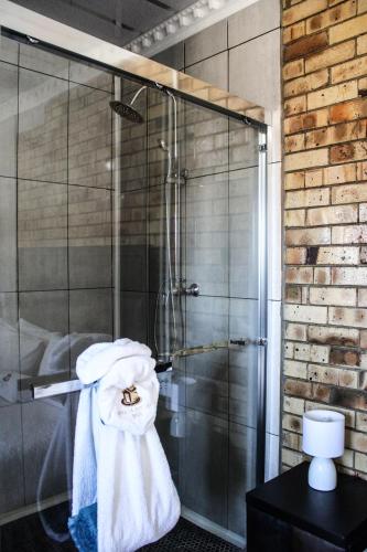a glass shower stall with a towel on it at Siyaya Sbosh BnB in Reitz