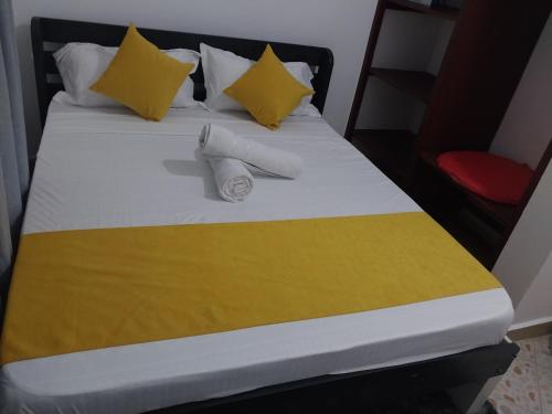 ウクンダにあるSerene Stay Dianiのベッド(黄色と白のシーツ、枕付)
