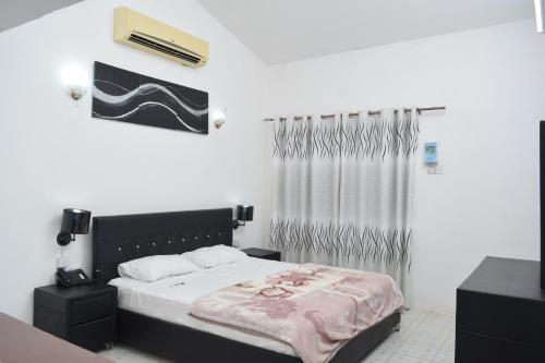 a bedroom with a bed with a black headboard at Fun City Water & Theme Park in Dar es Salaam