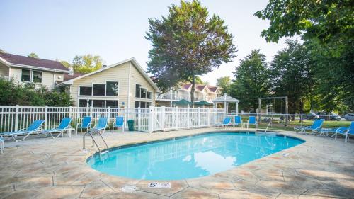 una piscina con sillas azules y una valla blanca en Somerset Inn & Suites, en Ephraim
