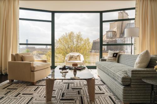 a living room with a couch and chairs and a large window at Cheval Blanc Paris & Dior Spa Cheval Blanc Paris in Paris
