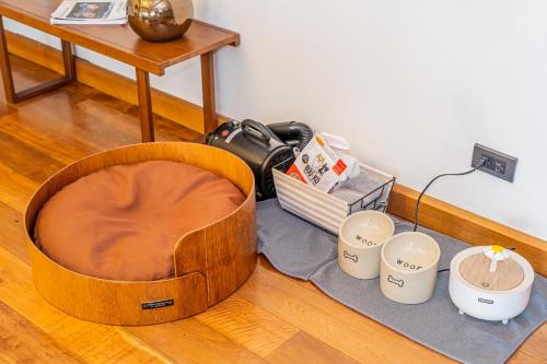a wooden ottoman sitting on the floor next to cups at Te Mata Glamping in Nong Nam Daeng