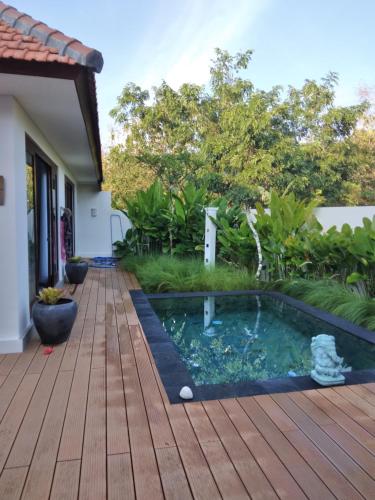 a backyard with a pool and a wooden deck at The Seaglass Villas Bingin in Uluwatu