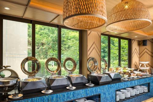 a buffet with dishes and mirrors on a counter at The Proud Karon Beach Phuket Trademark Collection By Wyndham in Karon Beach