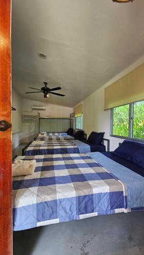 a bedroom with two beds and a ceiling fan at Kampung B&B Homestay in Kampong Sorosob