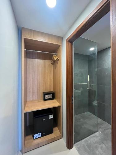 a bathroom with a walk in shower and a glass door at Horison Le Aman Bali in Jimbaran