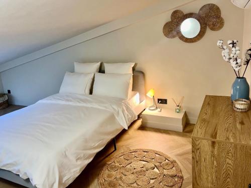 une chambre avec un grand lit blanc et une table dans l'établissement Bella Citadella, à Bastia