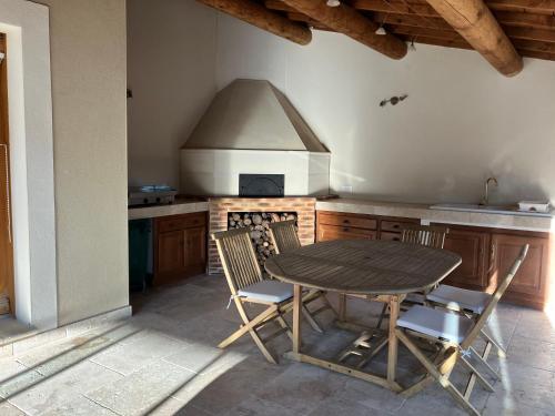 une cuisine avec une table, des chaises et une cuisinière dans l'établissement Mazet des Cèdres au pied de la colline, à Lagnes