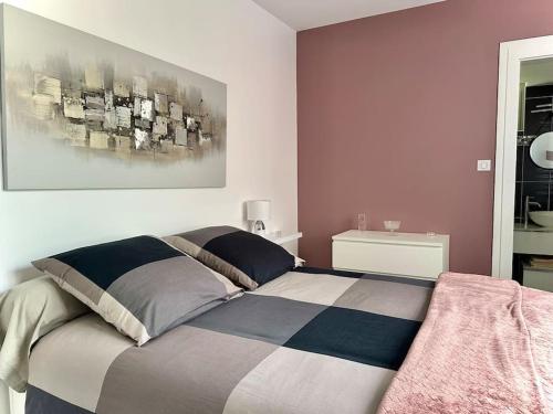 une chambre avec un lit avec un tableau sur le mur dans l'établissement La terrasse fleurie, à Salies-du-Salat