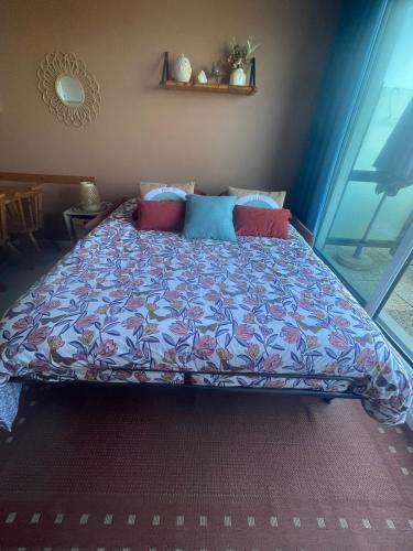 une chambre avec un lit avec une couette colorée dans l'établissement Escapade iodée à la Naturelle Vue mer- Wifi- Wimereux Côte d'opale, à Wimereux