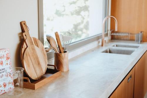 - un comptoir de cuisine avec évier et ustensiles de cuisine en bois dans l'établissement Élégance et Luxe au Rayol Canadel, à Rayol-Canadel-sur-Mer