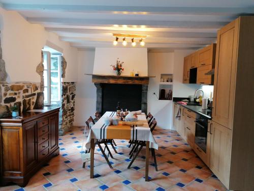 une cuisine avec une table et des chaises ainsi qu'une cheminée dans l'établissement Maison Lesgarenia, à Irissarry