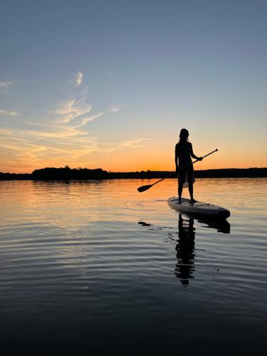 a person on a paddle board in the water at Guesthouse with 3 apartments, just outside Berlin, near to Tesla in Burig